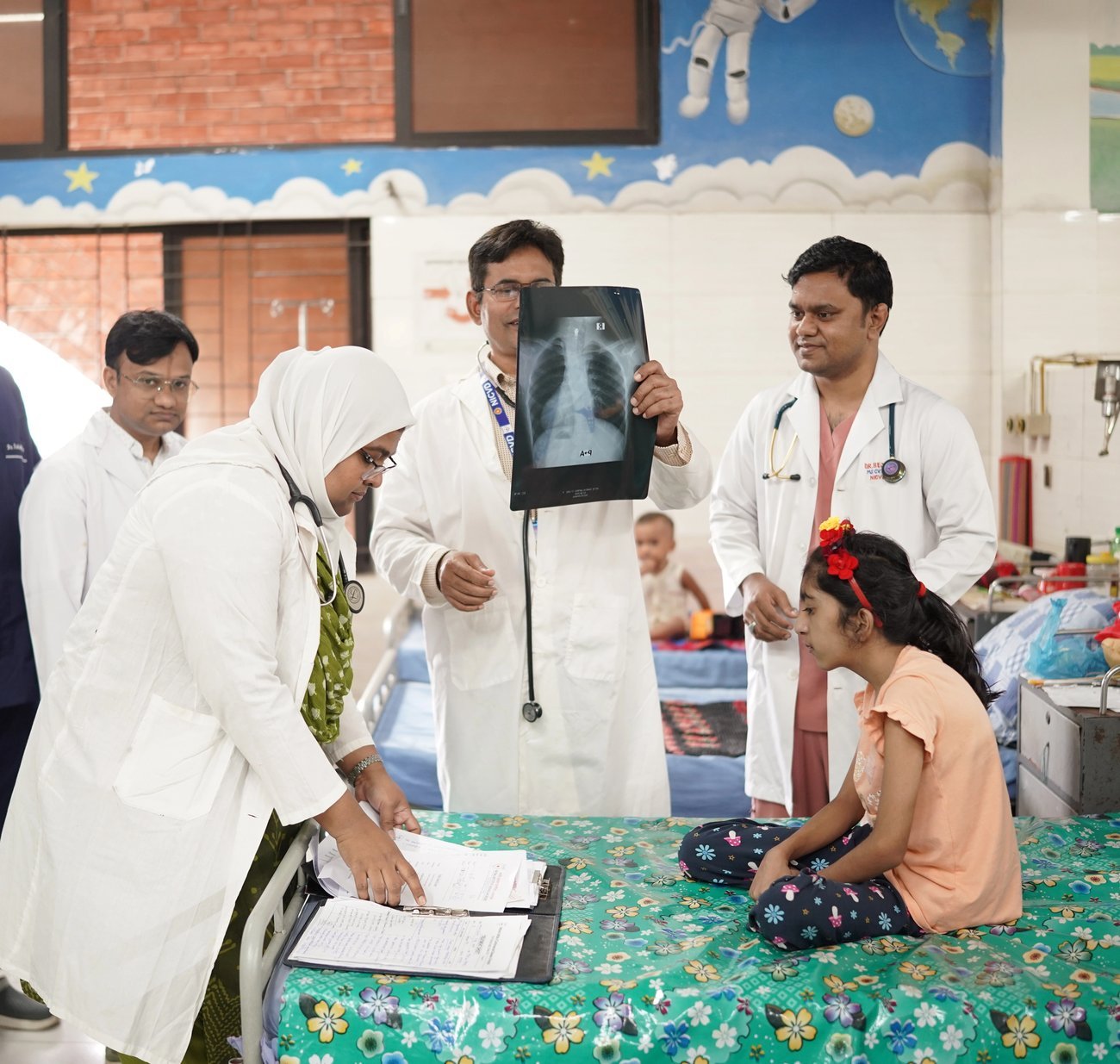 A consultant examines a chest X-ray during a ward round in the paediatric cardiac ward