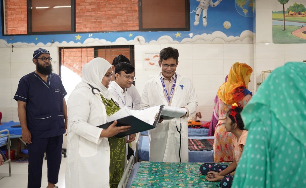 The paediatric team reviewing case notes at a child bedside