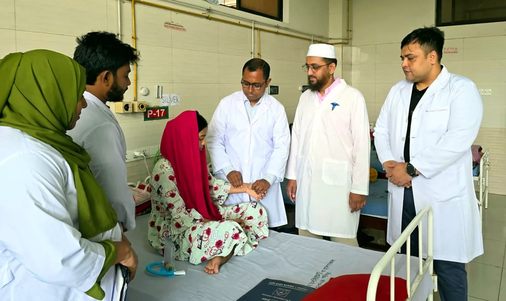 Doctors reviewing a patient at the bedside in the cardiac surgery ward, NICVD